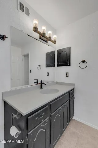 a view of a sink a mirror and cabinets