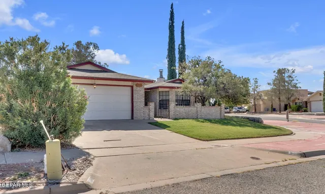a front view of a house with a yard and trees