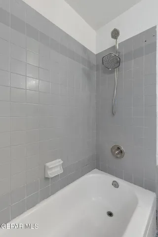 a bathroom with a white bath tub a shower and a sink