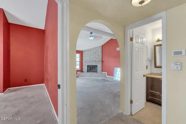 a view of an empty room with a fireplace and a window