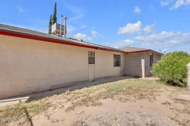a view of a house with a yard and potted plants