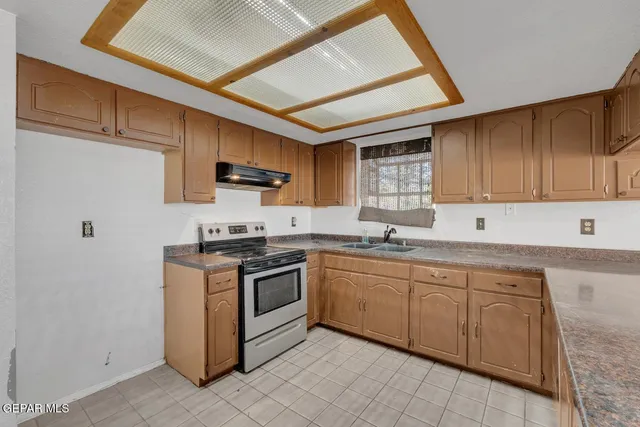 a kitchen with stainless steel appliances granite countertop a stove sink and cabinets