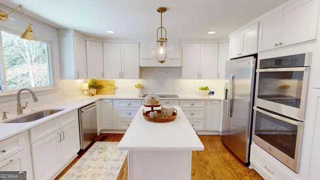 a kitchen with stainless steel appliances a stove a sink and a refrigerator