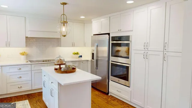 a kitchen with white cabinets and stainless steel appliances