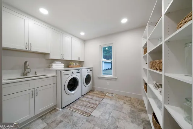 a utility room with sink dryer and washer