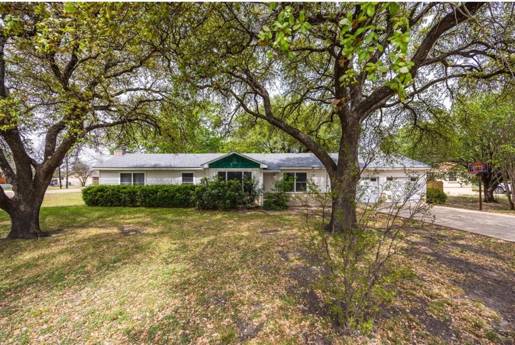 a front view of a house with yard and tree