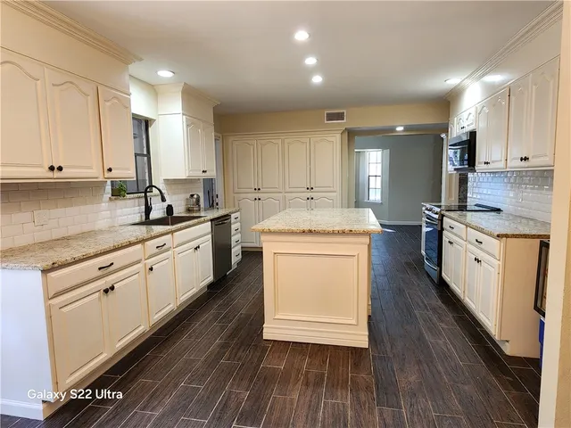 a kitchen with sink a stove and cabinets