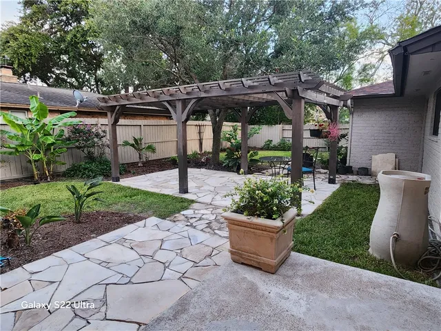 a view of a patio with a table and chairs under an umbrella