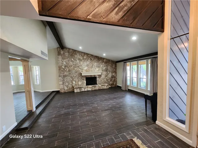 a view of an empty room with window and fire place