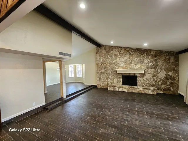 a view of an empty room with a fireplace and a window