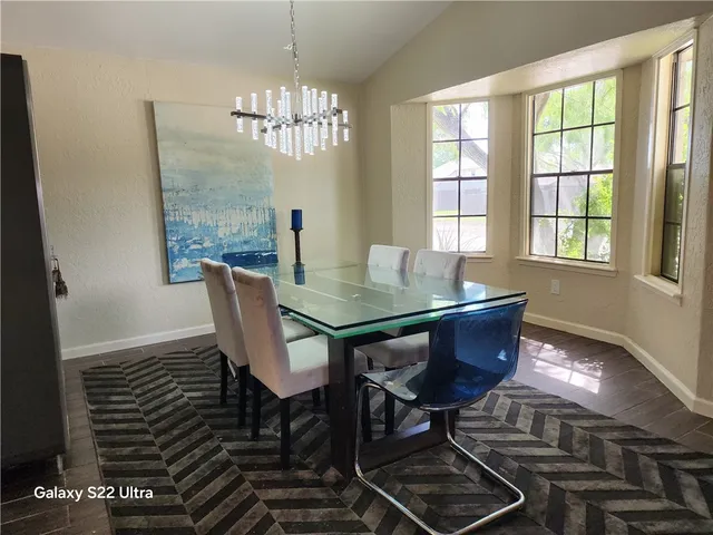 a view of a dining room with furniture a chandelier and wooden floor