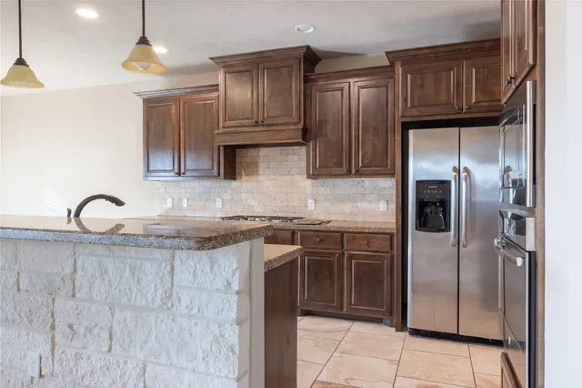 a kitchen with granite countertop stainless steel appliances and wooden cabinets
