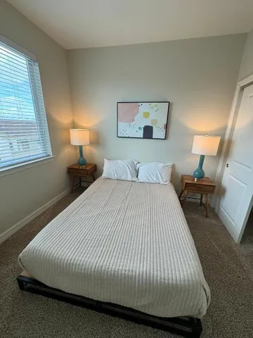 a bedroom with a bed and a night stand