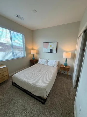 a spacious bedroom with a bed and a window