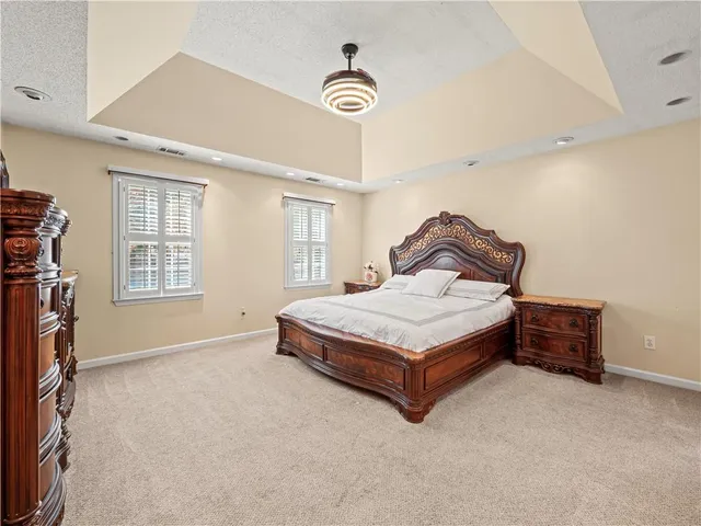 a spacious bedroom with a bed and a chandelier