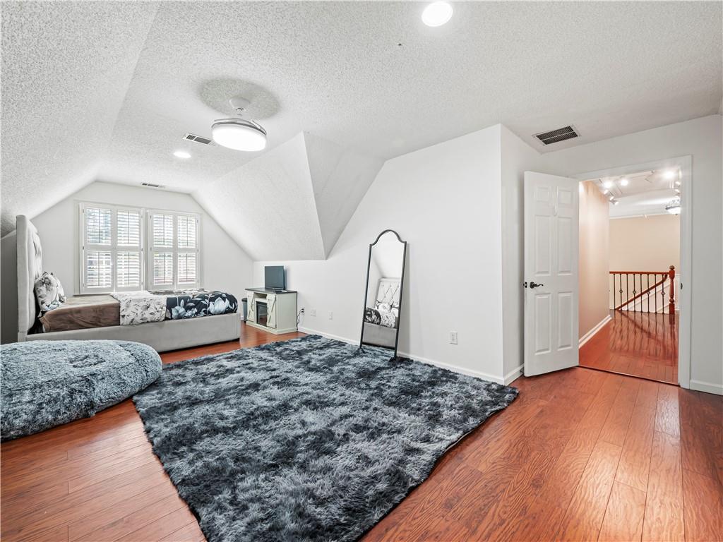 4465 Settles Bridge Road Suwanee, GA 30024 - Photo 31 of 52 a bedroom with a large bed and a dresser