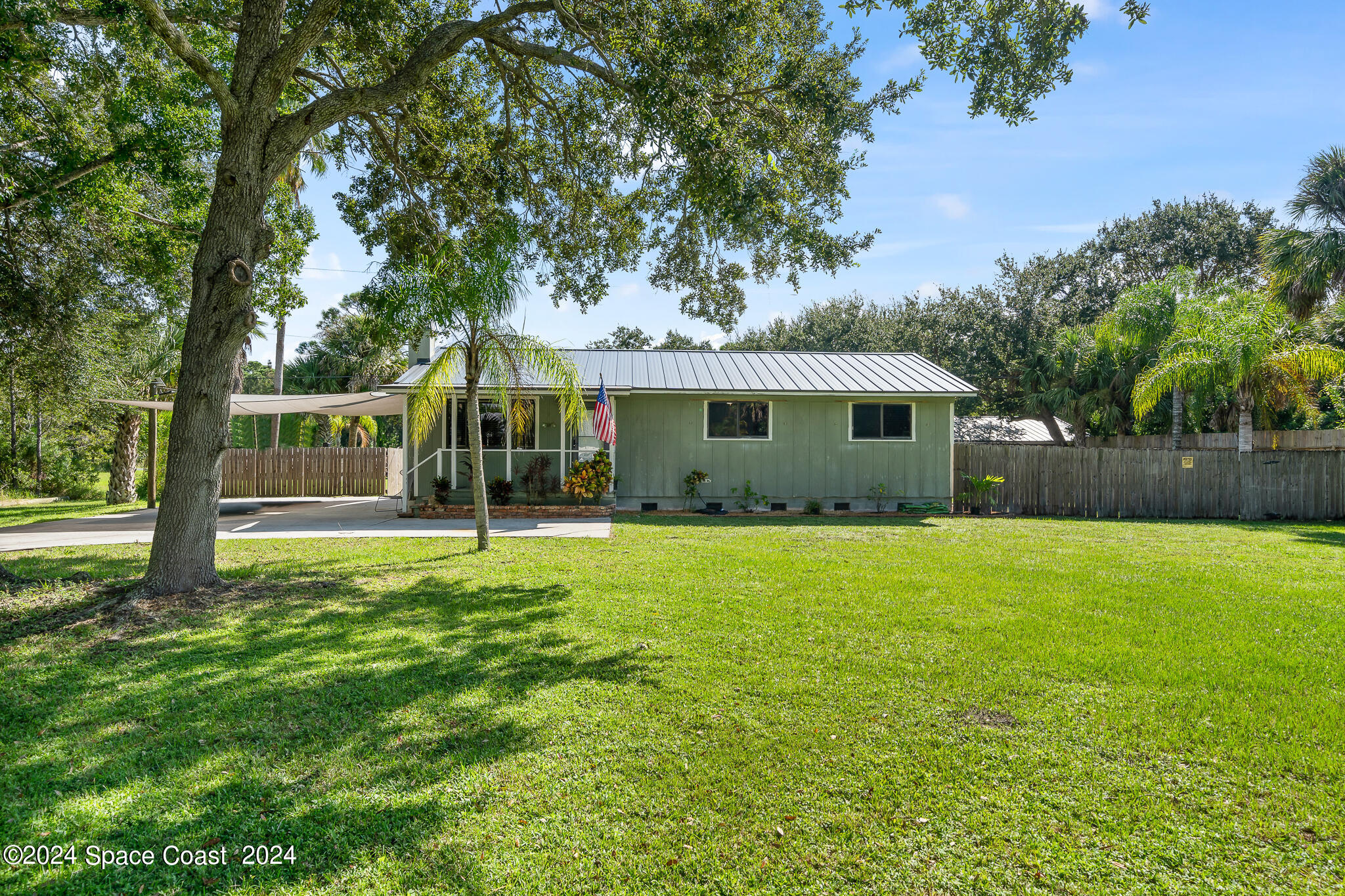 a view of a house with backyard and a tree