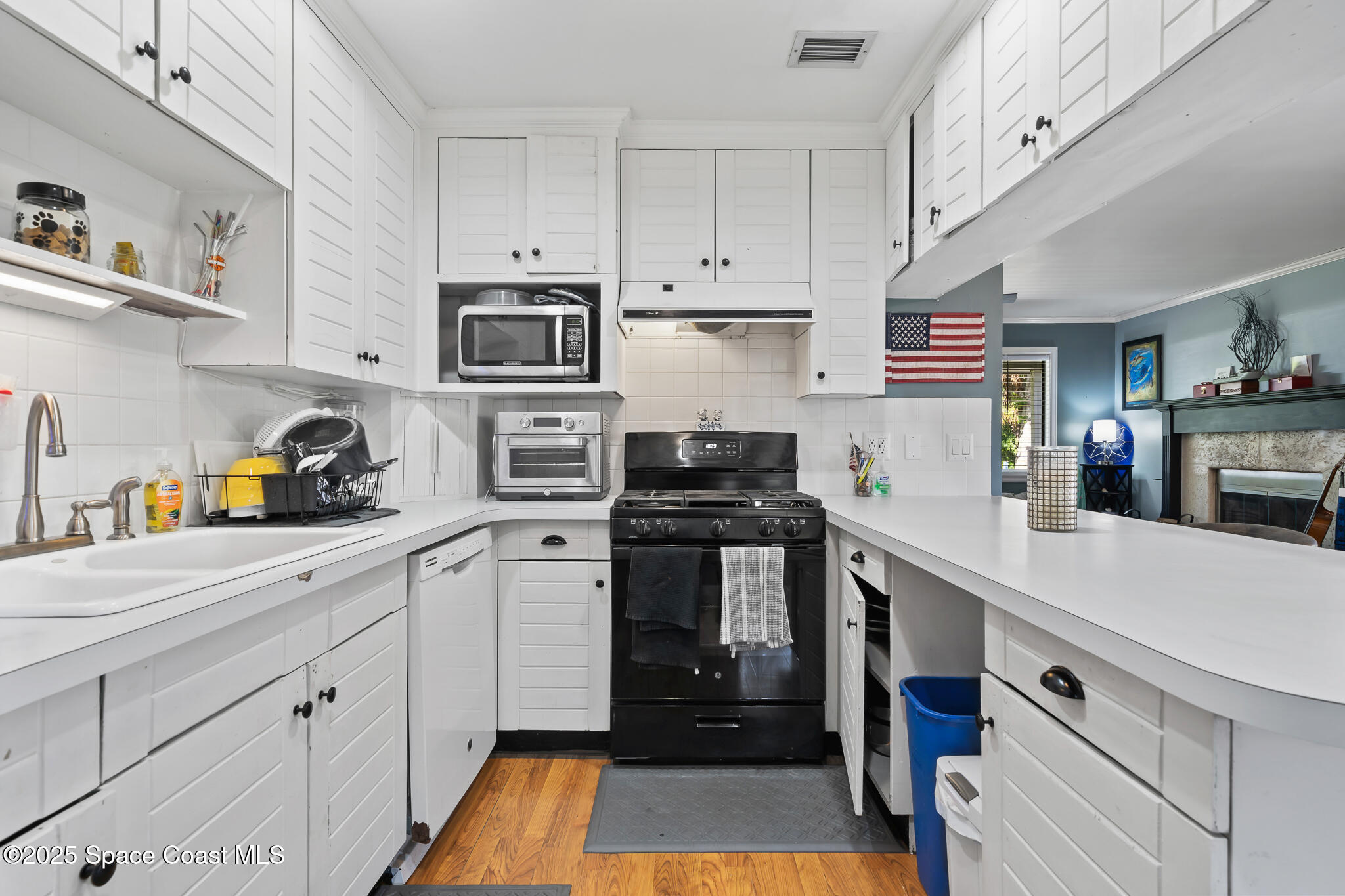 9633 Honeysuckle Drive Sebastian, FL 32976 - Photo 12 of 40 a kitchen with cabinets stainless steel appliances and wooden floor