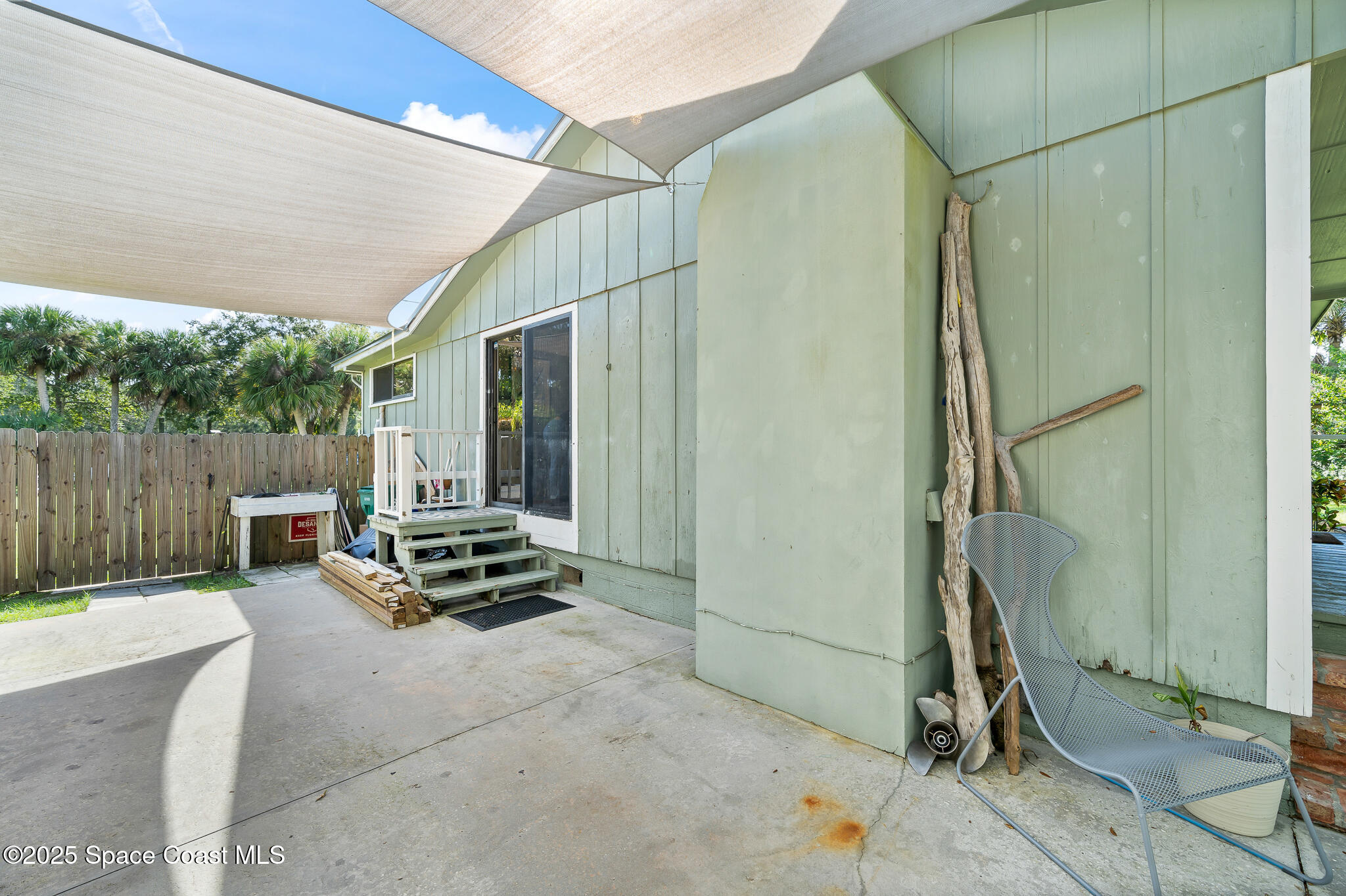 9633 Honeysuckle Drive Sebastian, FL 32976 - Photo 23 of 40 a backyard of a house with lawn chairs and wooden fence