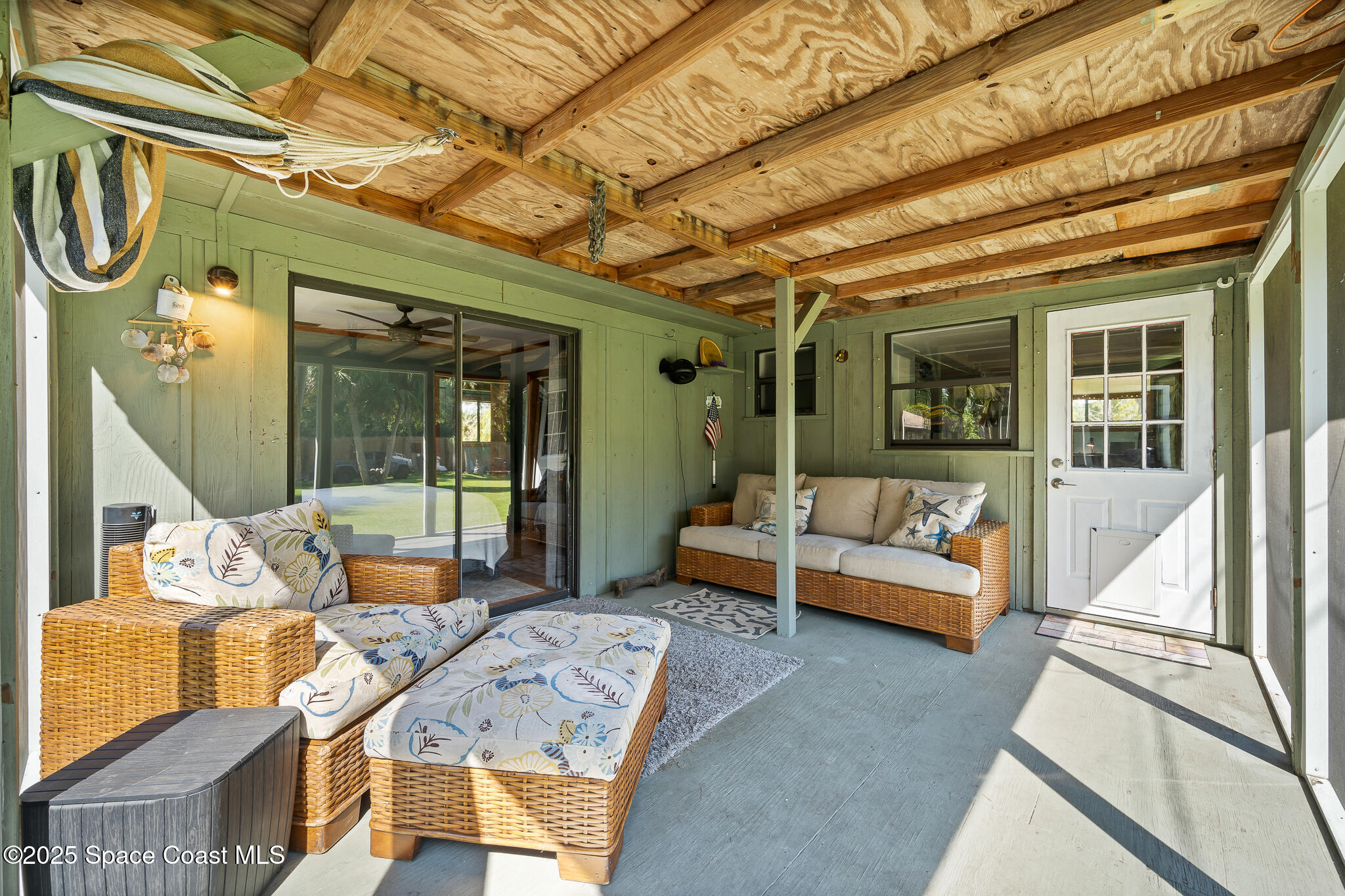 9633 Honeysuckle Drive Sebastian, FL 32976 - Photo 31 of 40 a view of a patio with couches chairs and wooden floor