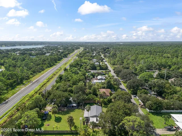 an aerial view of residential houses with outdoor space and trees