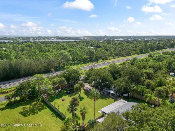 an aerial view of a house with a yard and lake view