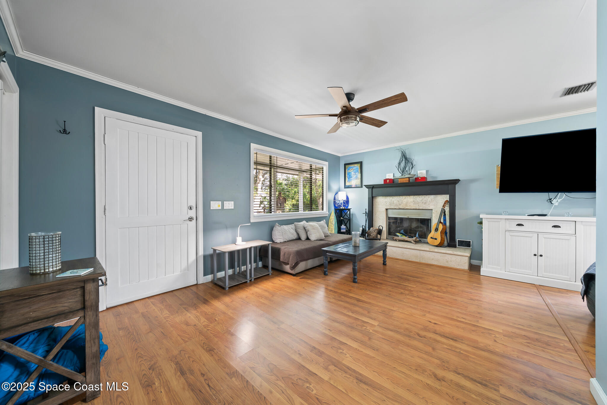 9633 Honeysuckle Drive Sebastian, FL 32976 - Photo 6 of 40 a living room with furniture a flat screen tv and a fireplace