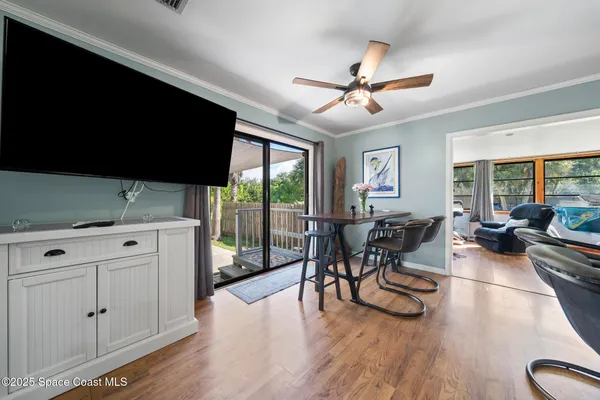 a kitchen with stainless steel appliances kitchen island hardwood floor sink stove dining table and chairs