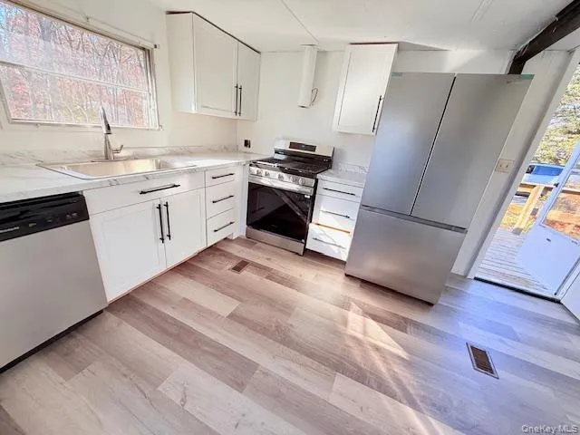 a kitchen with stainless steel appliances a refrigerator sink and microwave