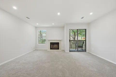 a view of an empty room with a fireplace and a window