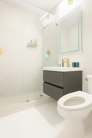 a bathroom with a sink a toilet and shower