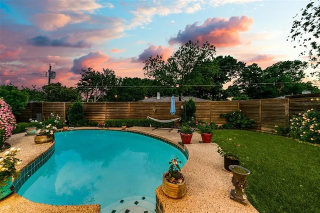 a view of a swimming pool with a yard and a tub