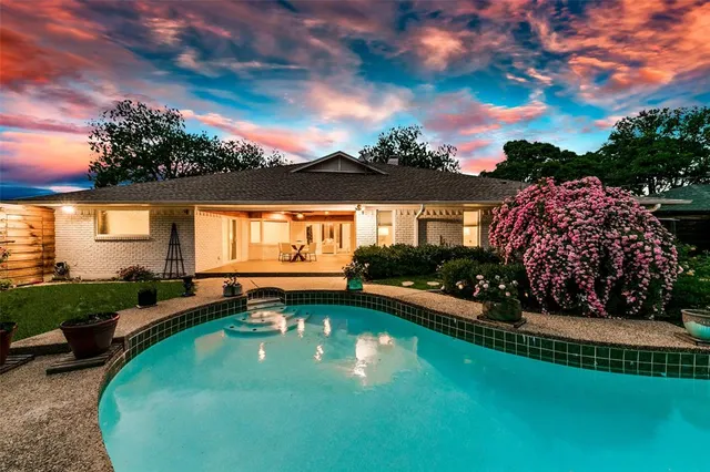 a view of a house with swimming pool and a yard