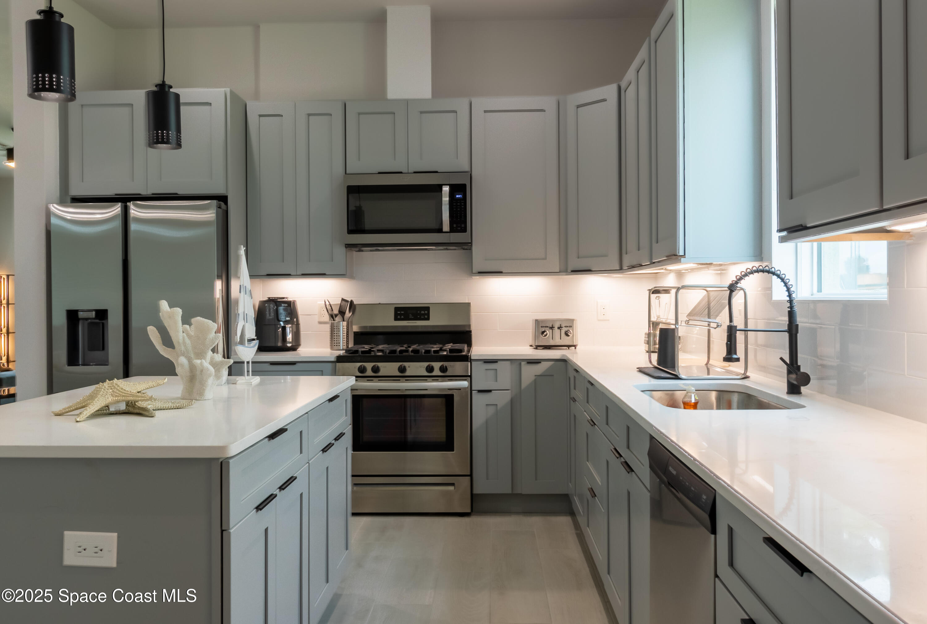 2148 Country Club Road Melbourne, FL 32901 - Photo 12 of 30 a kitchen with stainless steel appliances a sink a stove a microwave a sink and refrigerator