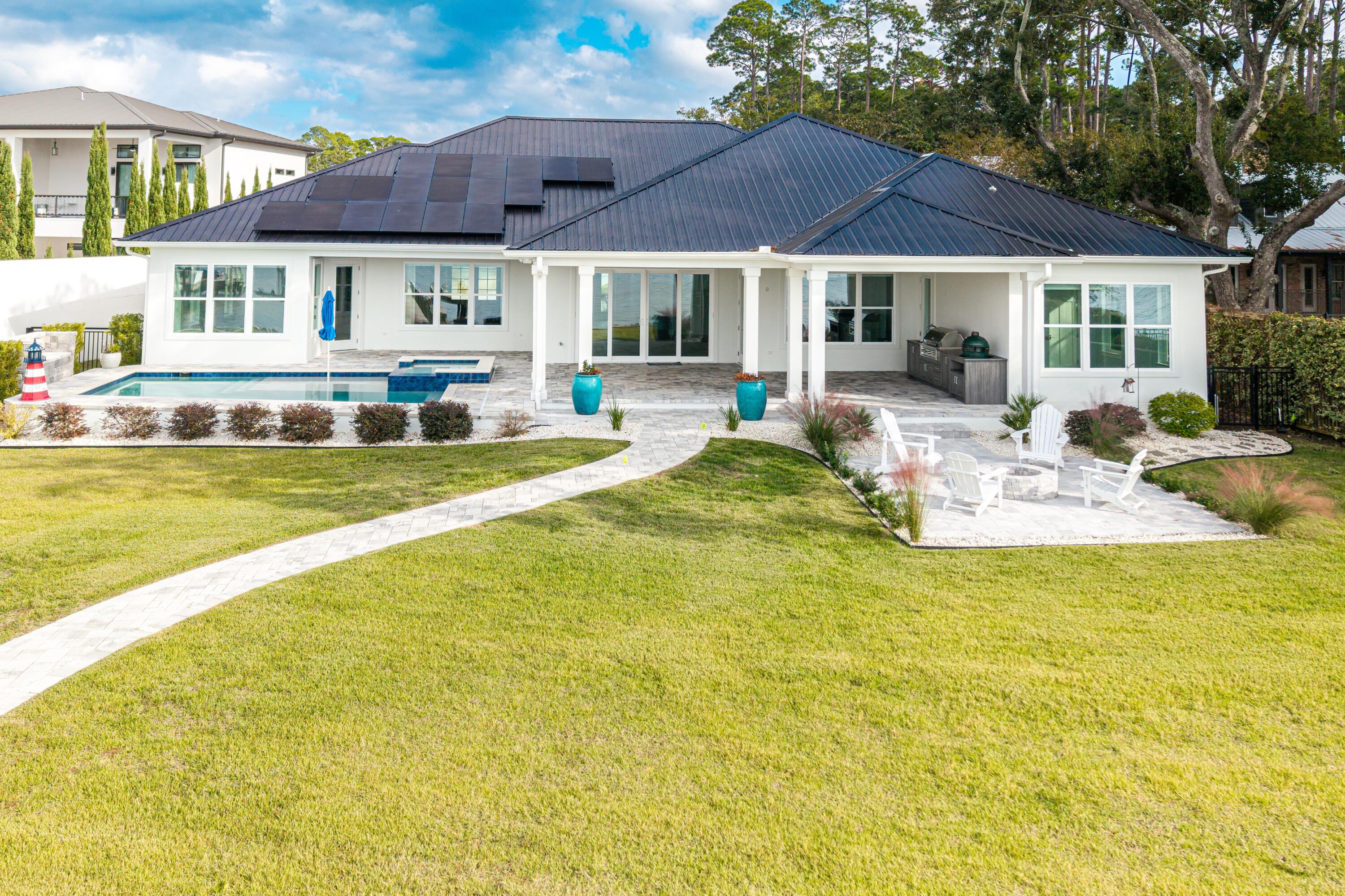 399 Driftwood Point Road Santa Rosa Beach, FL 32459 - Photo 72 of 94 a view of a swimming pool with couches chairs under an umbrella