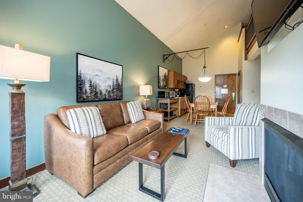 a living room with furniture a couch and paintings on the wall