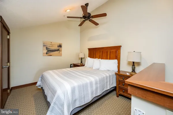 a bedroom with a bed and a ceiling fan