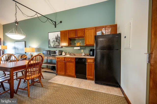 a kitchen with stainless steel appliances granite countertop a refrigerator a sink a stove and a refrigerator