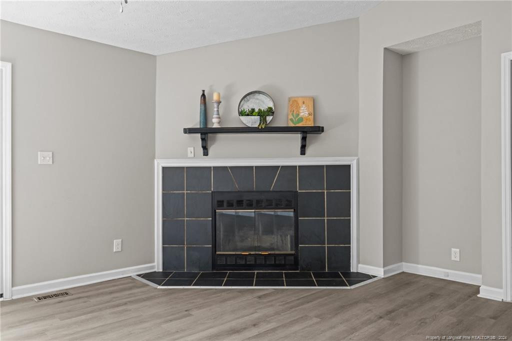 124 East Lake Ridge Road Raeford, NC 28376 - Photo 11 of 44 a view of a livingroom with wooden floor and a fireplace