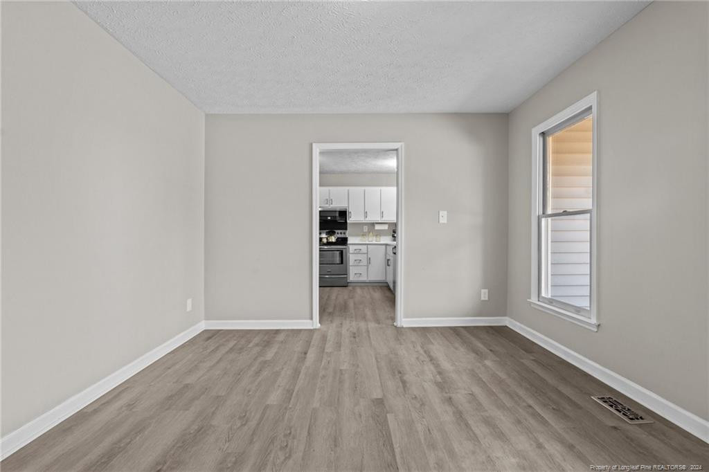 124 East Lake Ridge Road Raeford, NC 28376 - Photo 13 of 44 wooden floor in an empty room with a window