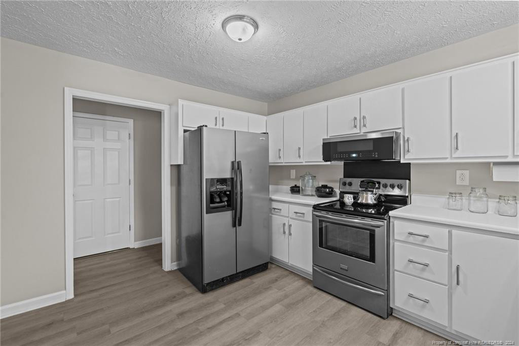 124 East Lake Ridge Road Raeford, NC 28376 - Photo 18 of 44 a kitchen with cabinets stainless steel appliances and wooden floor