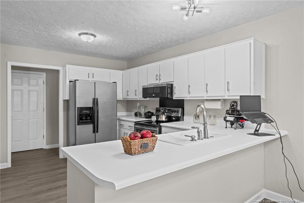 124 East Lake Ridge Road Raeford, NC 28376 - Photo 19 of 44 a kitchen with a sink a stove and cabinets