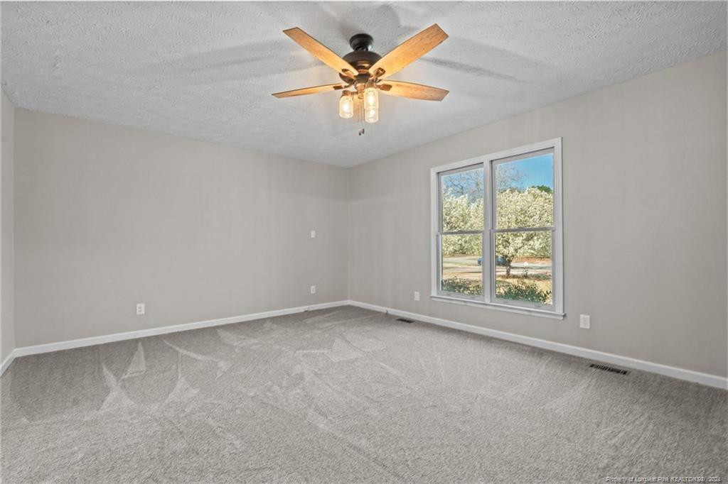 124 East Lake Ridge Road Raeford, NC 28376 - Photo 22 of 44 an empty room with windows and ceiling fan