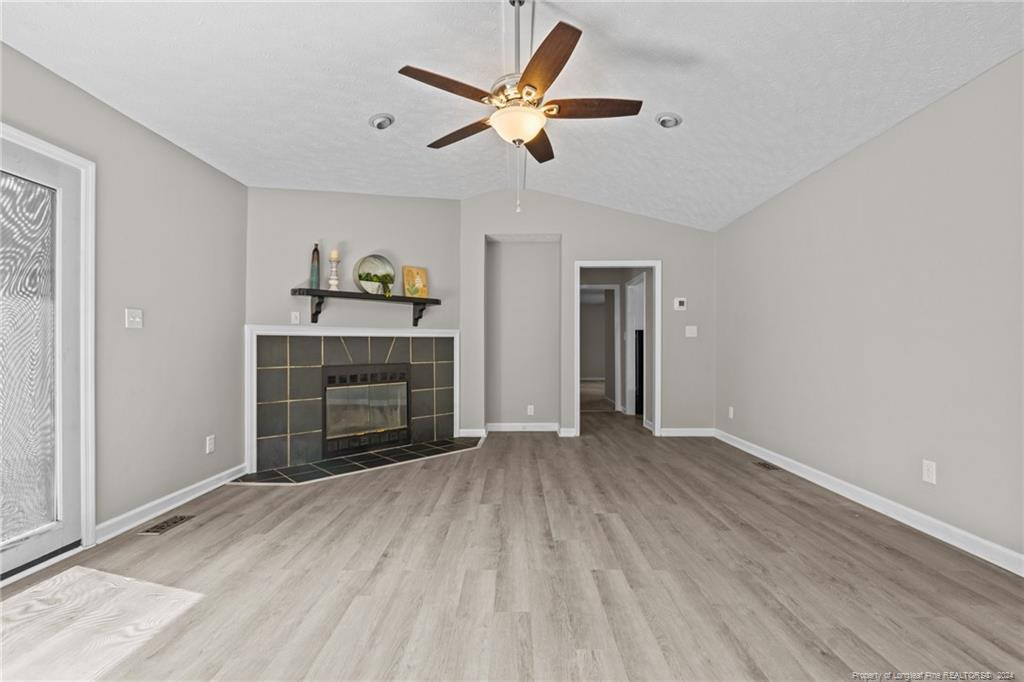 124 East Lake Ridge Road Raeford, NC 28376 - Photo 9 of 44 a big room with wooden floor and a ceiling fan