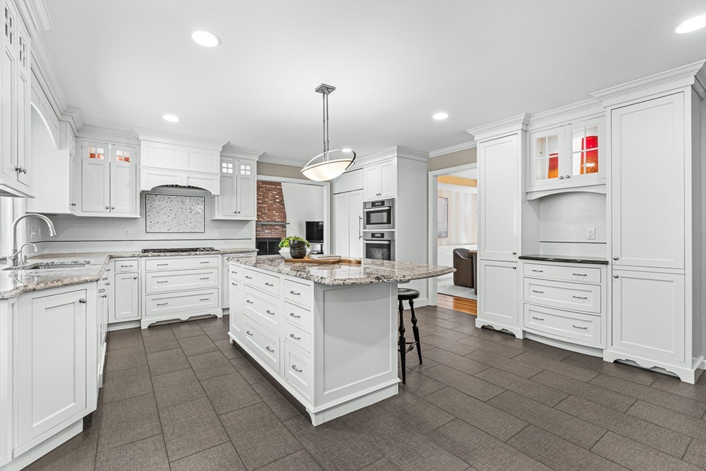 20 Algonquian Drive Natick, MA 01760 - Photo 11 of 40 a kitchen with kitchen island granite countertop a stove oven and a refrigerator