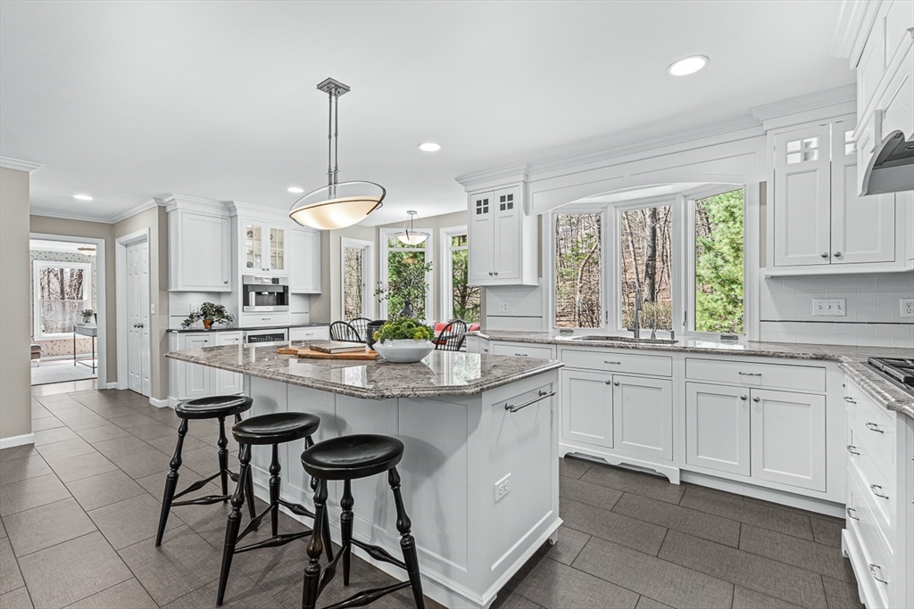 20 Algonquian Drive Natick, MA 01760 - Photo 12 of 40 a kitchen with stainless steel appliances kitchen island a large island in the center a sink a window and cabinets