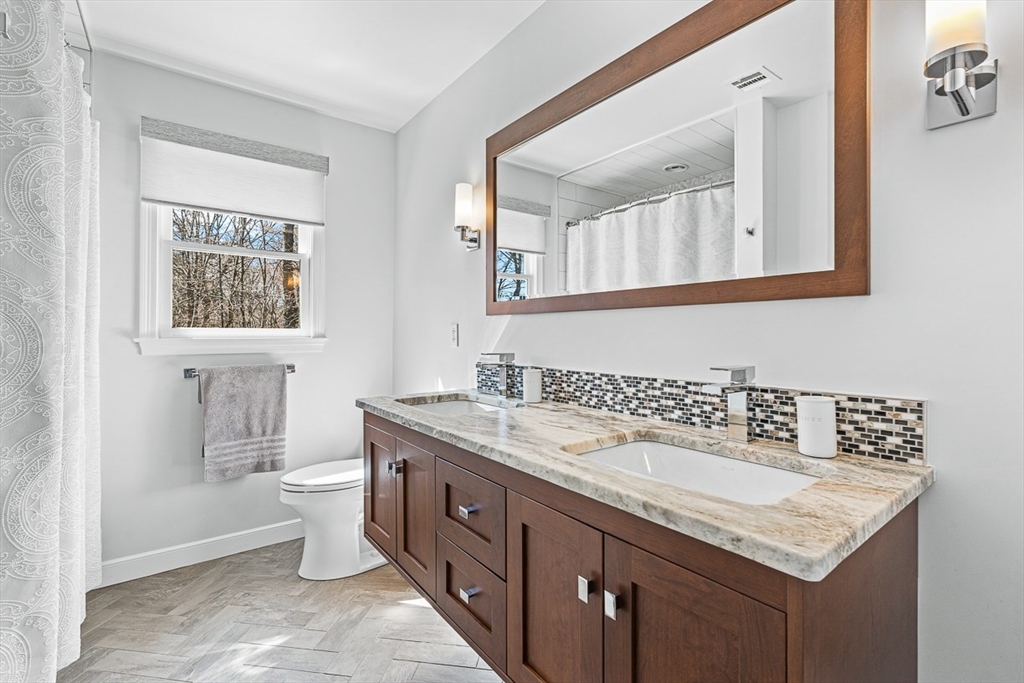 20 Algonquian Drive Natick, MA 01760 - Photo 29 of 40 a bathroom with a granite countertop sink a toilet and a mirror