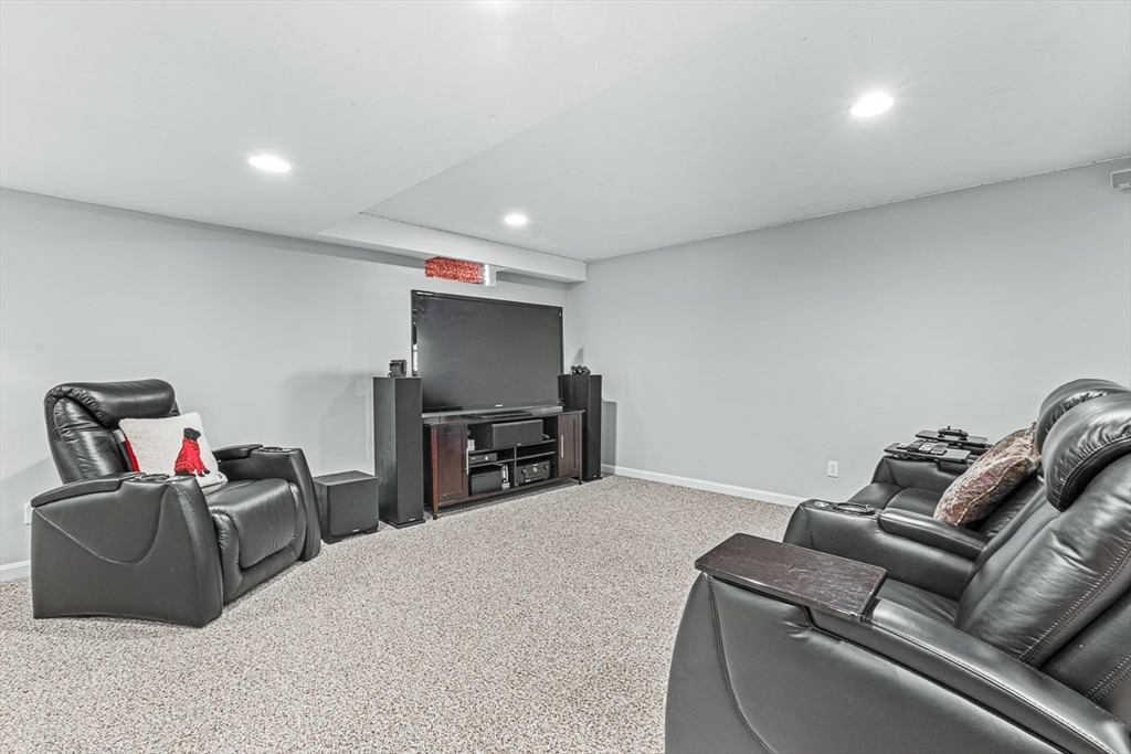 20 Algonquian Drive Natick, MA 01760 - Photo 31 of 40 a living room with furniture a projector and a flat screen tv