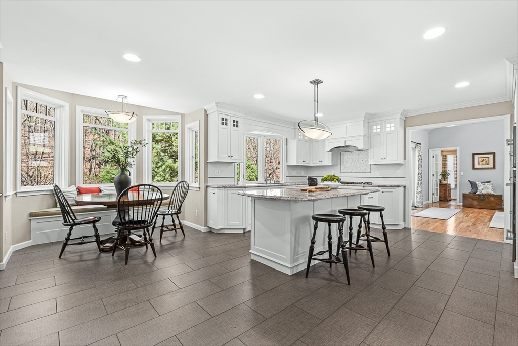 20 Algonquian Drive Natick, MA 01760 - Photo 8 of 40 a kitchen with kitchen island granite countertop wooden cabinets and dining table chairs