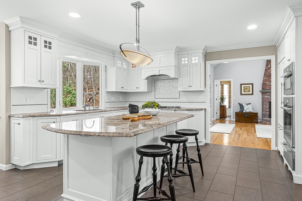 20 Algonquian Drive Natick, MA 01760 - Photo 9 of 40 a kitchen with stainless steel appliances granite countertop a sink a stove a refrigerator cabinets and living room view